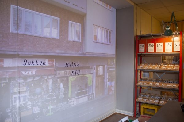 Photo of shop projected on wall, writing with new letters.